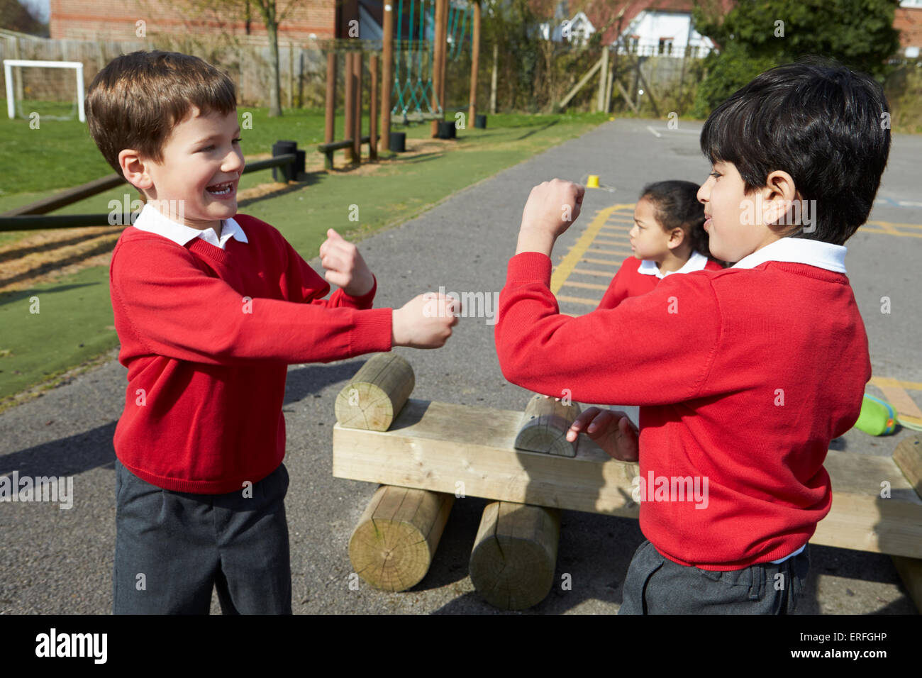 Due ragazzi combattimenti nel parco giochi a scuola Foto Stock