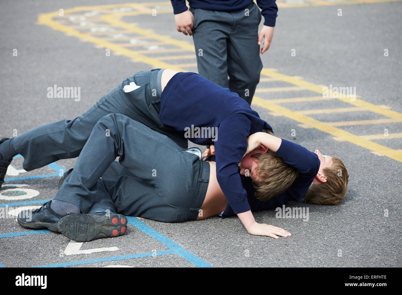 Due ragazzi combattimenti nel parco giochi a scuola Foto Stock