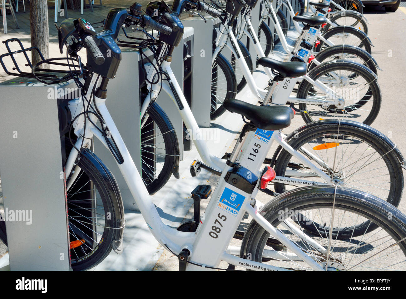 Fila di per BiciMad noleggio biciclette elettriche nelle loro gabbie di carica, Madrid, Spagna Foto Stock