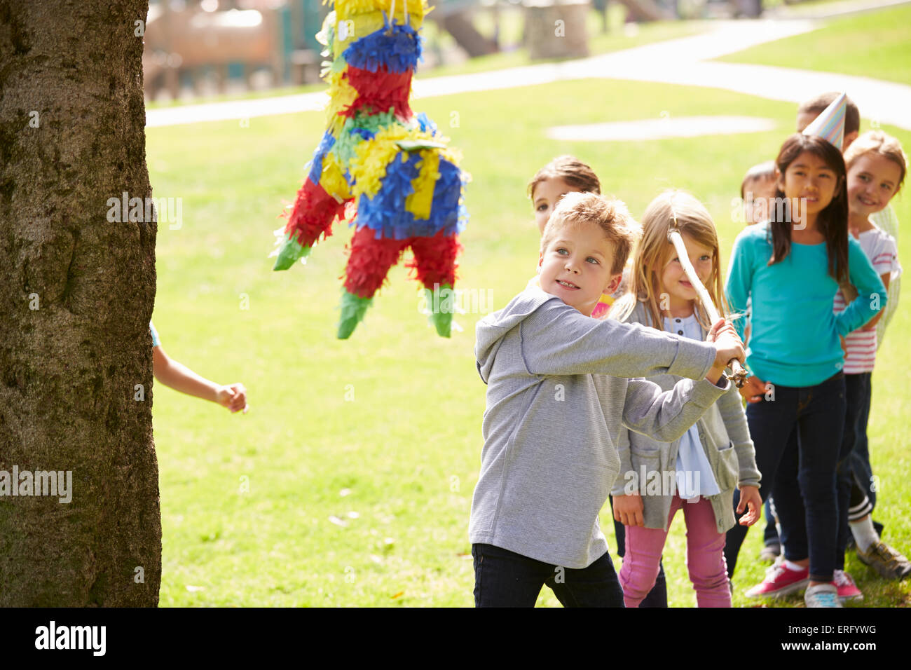 Bambini colpendo Pinata alla festa di compleanno Foto Stock