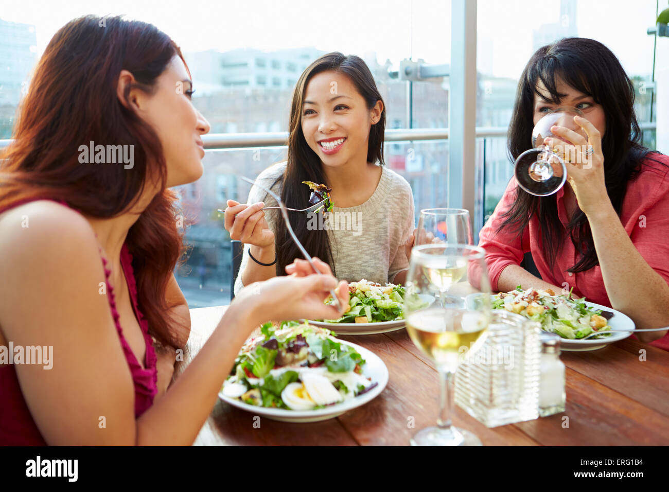 Tre Amiche godendo il pranzo al ristorante sul tetto Foto Stock