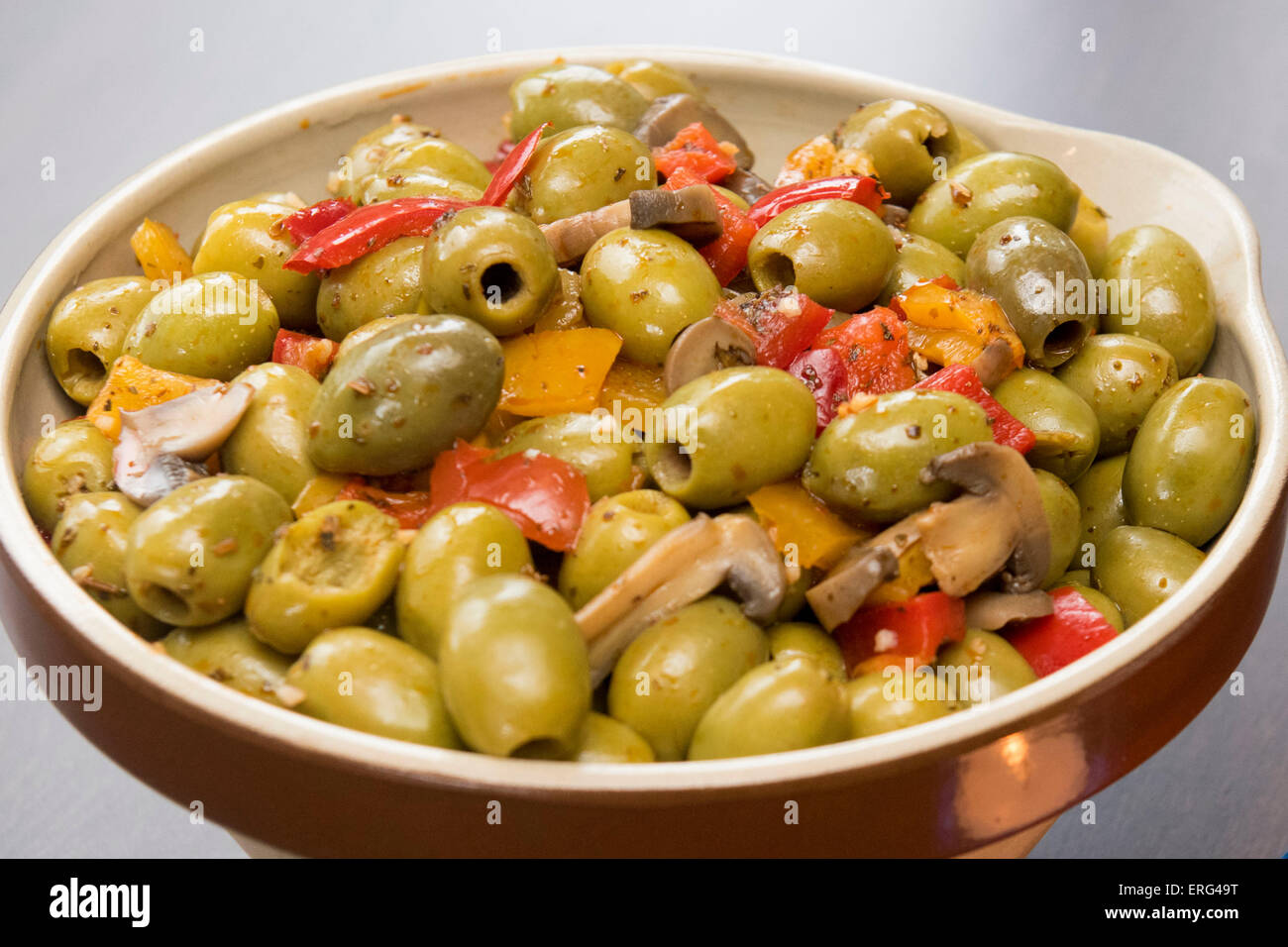 Una tazza di olive verdi serviva come tapas durante un pasto italiano. Foto Stock