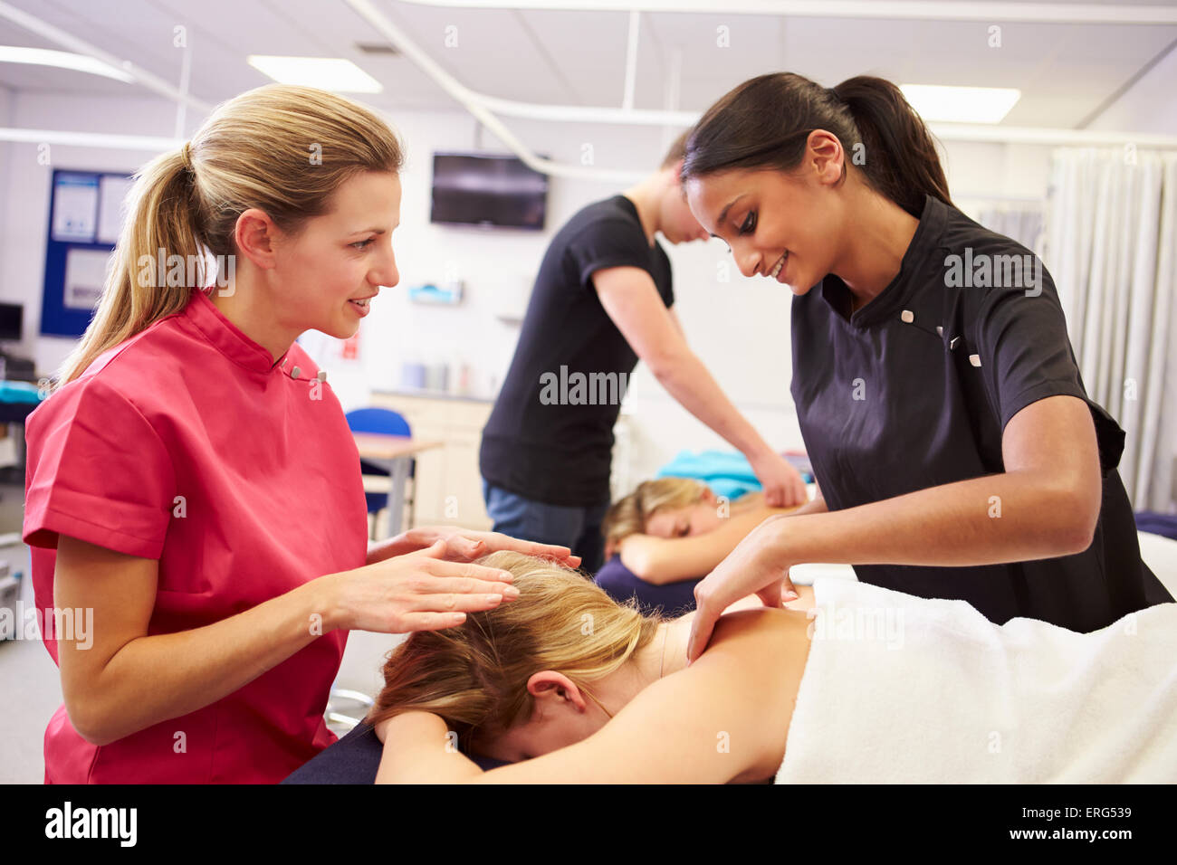 Insegnante contribuendo alla formazione degli studenti a diventare massaggiatrice Foto Stock