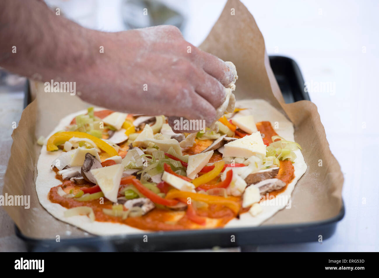 Pizza vegetariana essendo realizzati in un vassoio da forno. Foto Stock