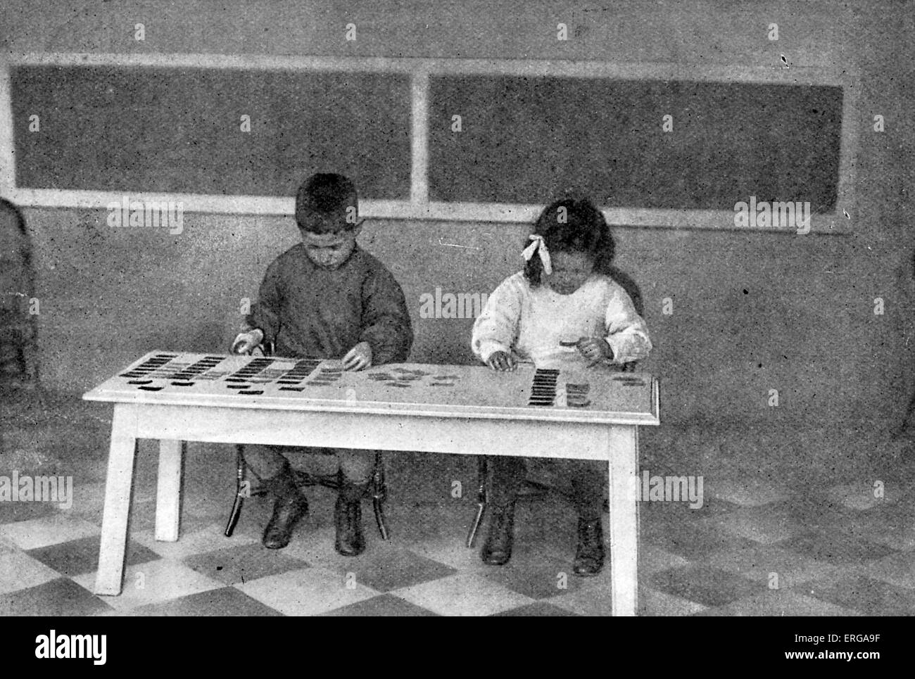 Montessori metodo di insegnamento - inizio del XX secolo. I bambini che lavorano con schede di lingua (la commercializzazione di articoli e sostantivi insieme). Foto Stock
