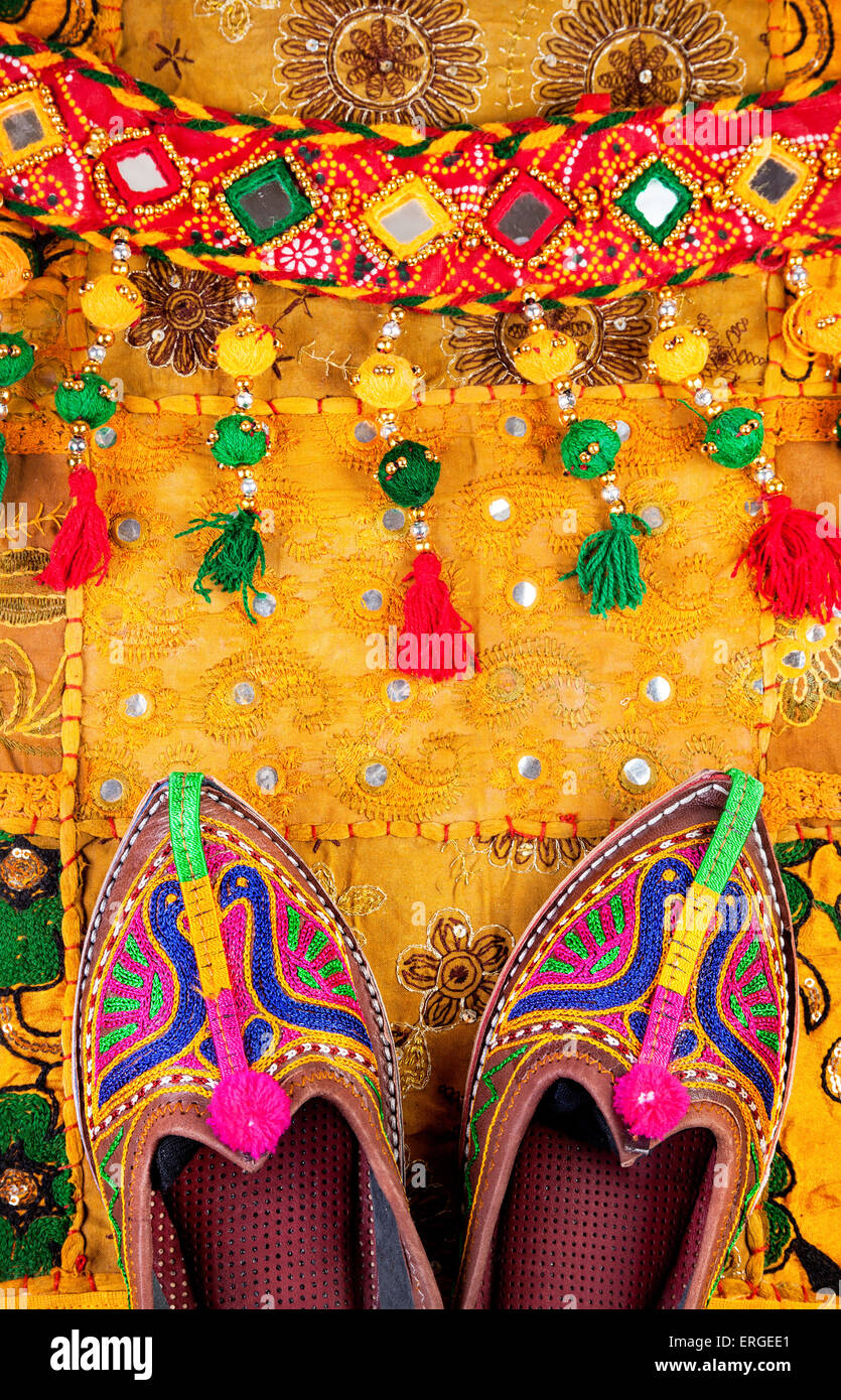 Colorate scarpe etniche e gipsy cintura gialla sul cuscino del Rajasthan coperchio sul mercato delle pulci in India Foto Stock