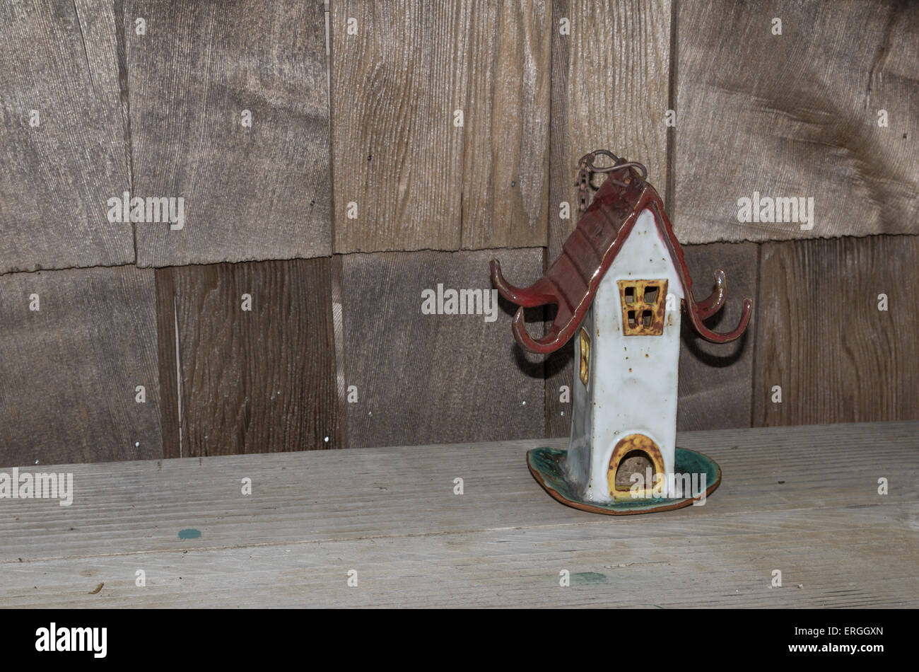 Ceramica birdhouse su una rustica panca in legno Foto Stock