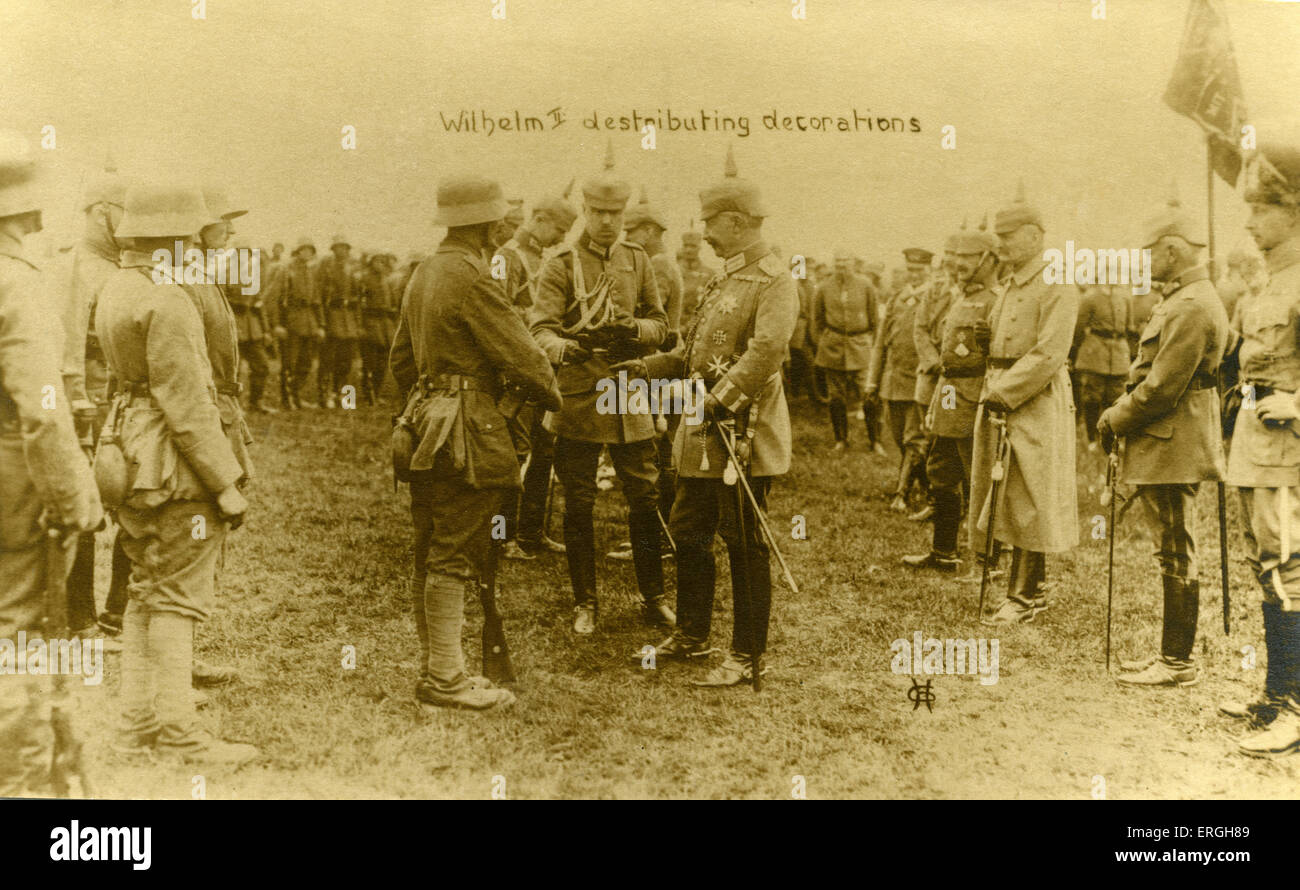 Guerra Mondiale 1: Kaiser Wilhelm II la distribuzione di decorazioni da soldati tedeschi nella parte anteriore. British cartolina. Foto Stock