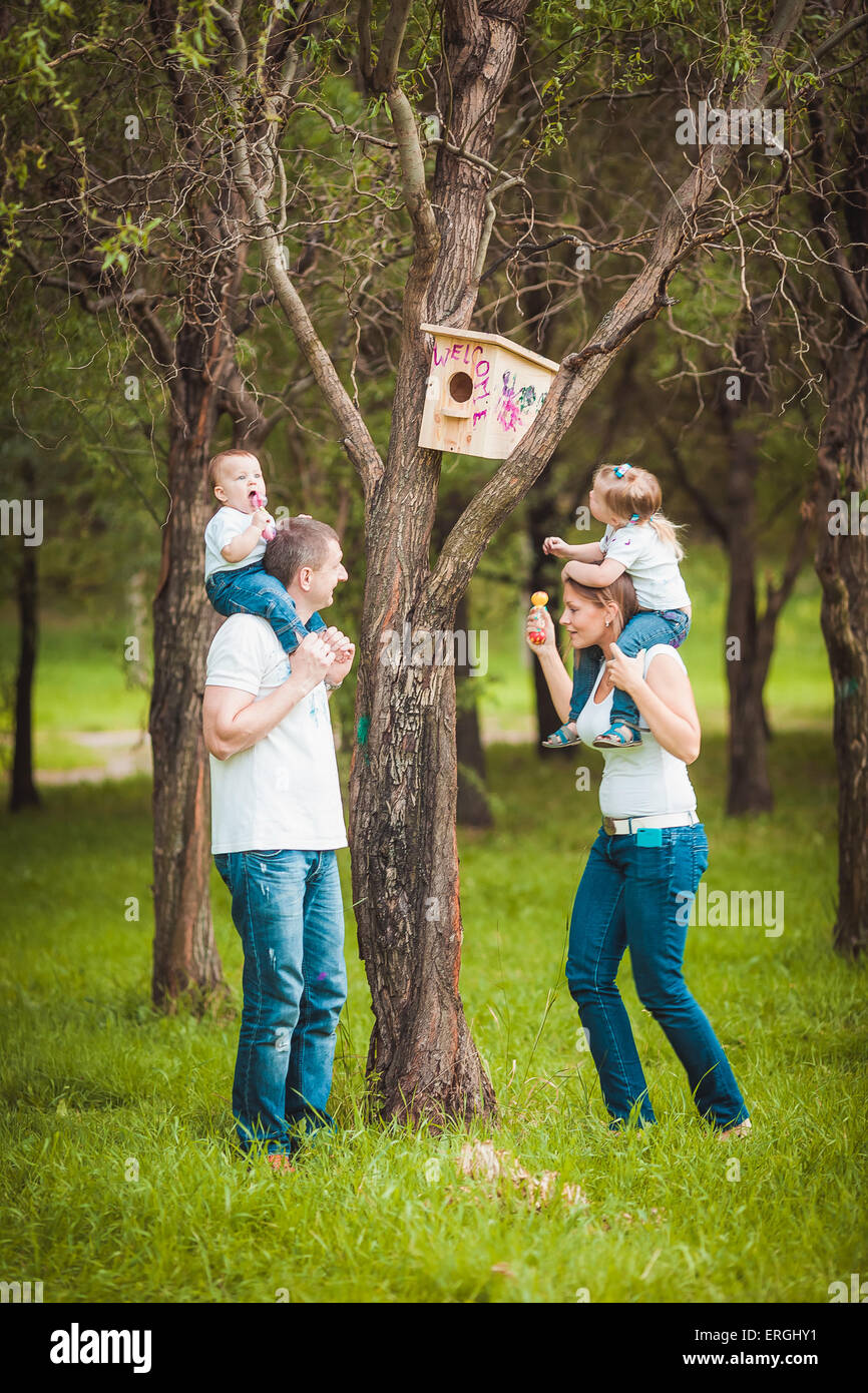 La famiglia felice con legno birdhouse Foto Stock
