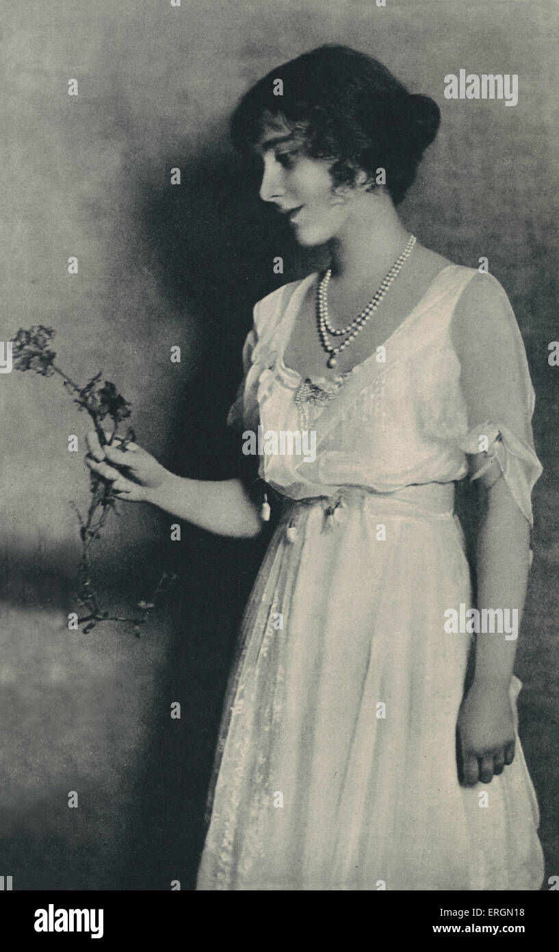 Queen Elizabeth, consorte del re George VI. Signora Elizabeth Bowes-Lyon (1900-2002) in posa con un garofano rosso prima di lei Foto Stock