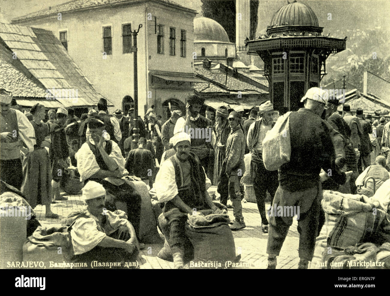 Til mercato di Sarajevo, Serbia. C. 1930s. Uomini che indossano il costume tradizionale con grandi sacchi di produrre. Una donna tra i Foto Stock