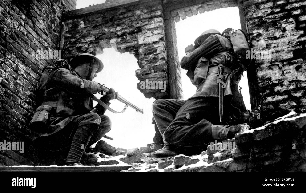 Durante la Seconda guerra mondiale - i soldati in edificio in rovina di guardare attraverso una finestra, uno indicando una pistola, gli altri guardando attraverso il binocolo. Didascalia Foto Stock