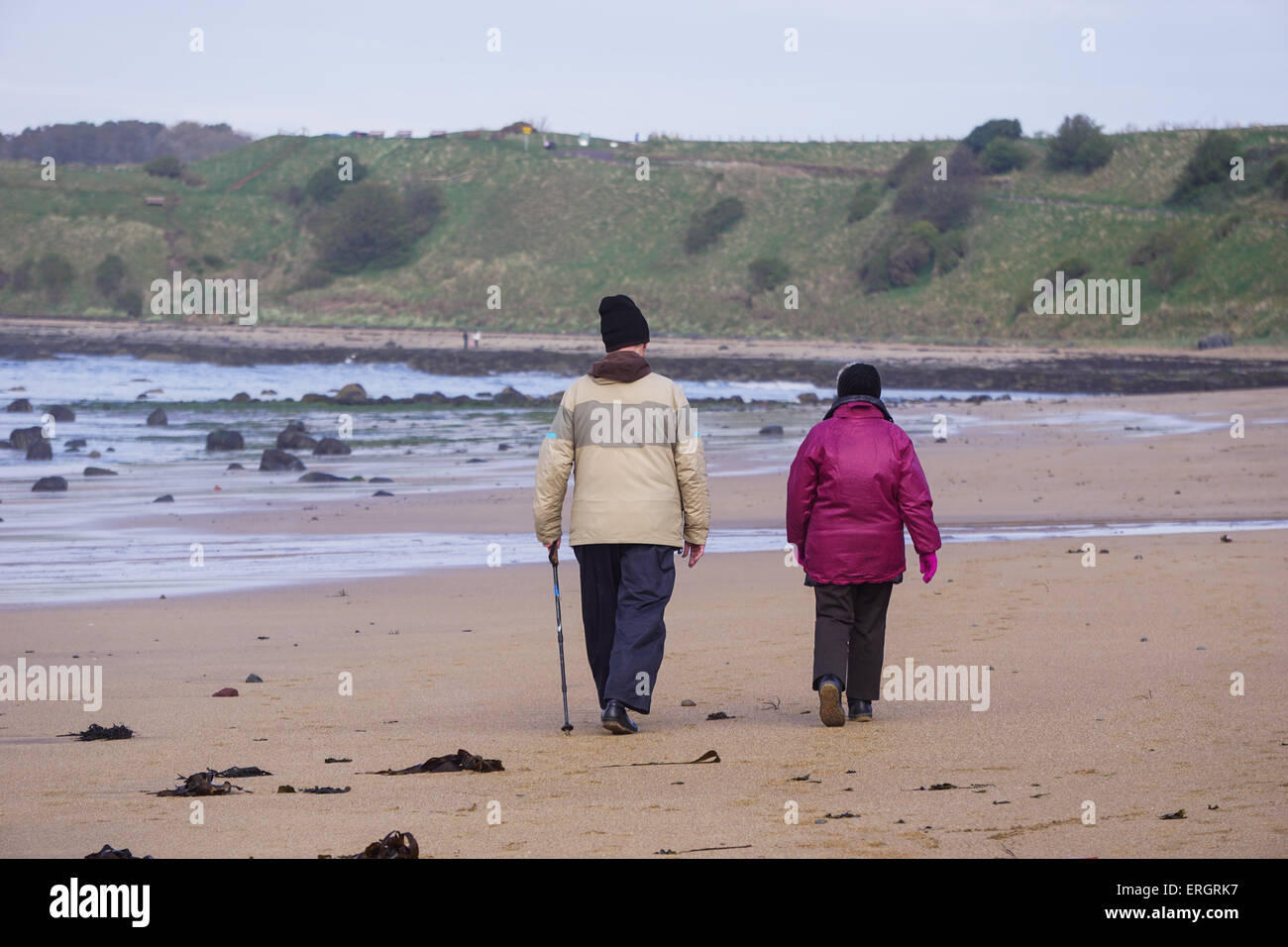 Coppia di anziani camminando sulla spiaggia Foto Stock
