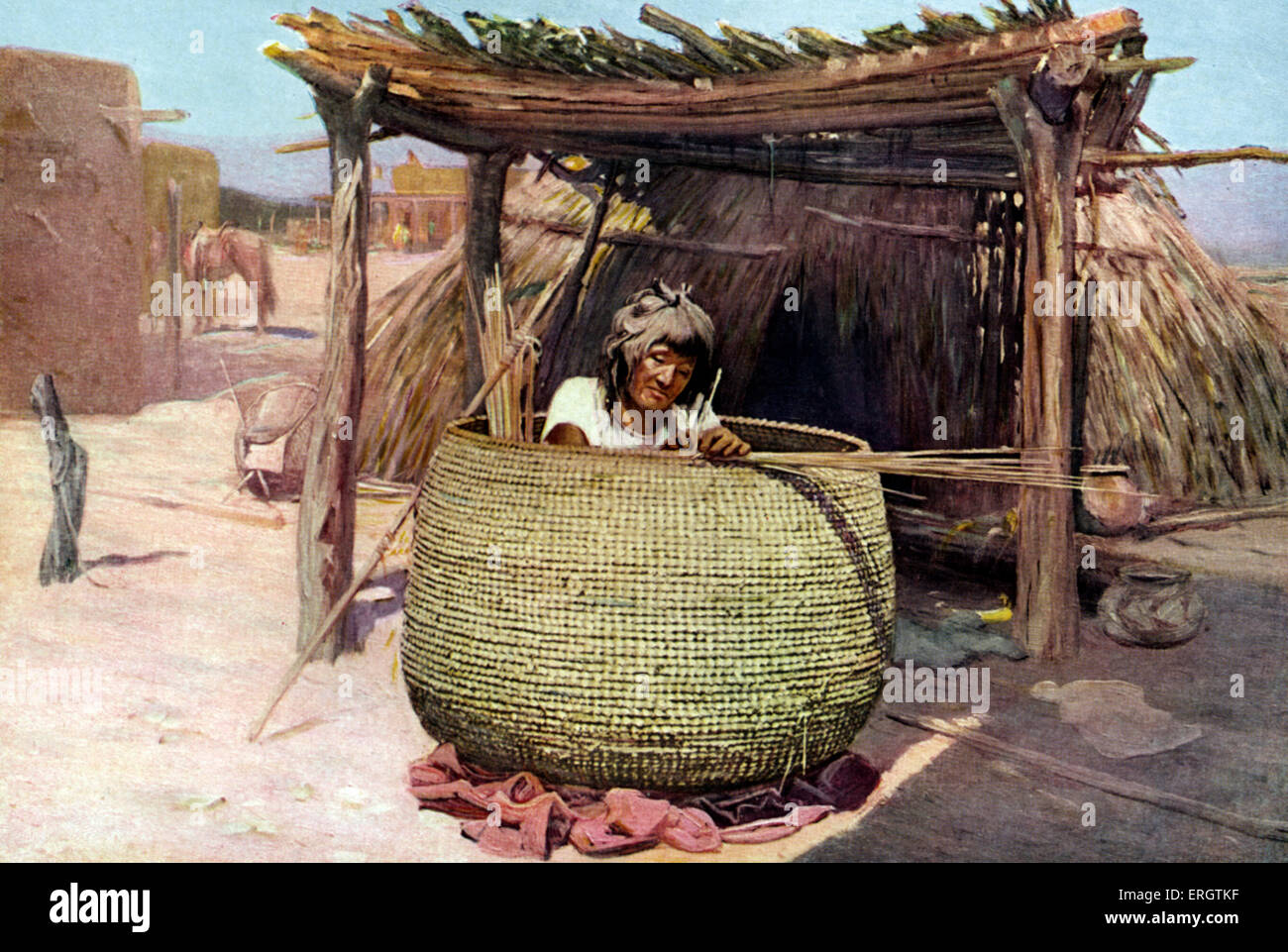 Nativi americani donna Apache - tessitura di un granaio (un grande cesto di alimentazione per immagazzinare grano e verdure). Pueblo indiano. American Foto Stock