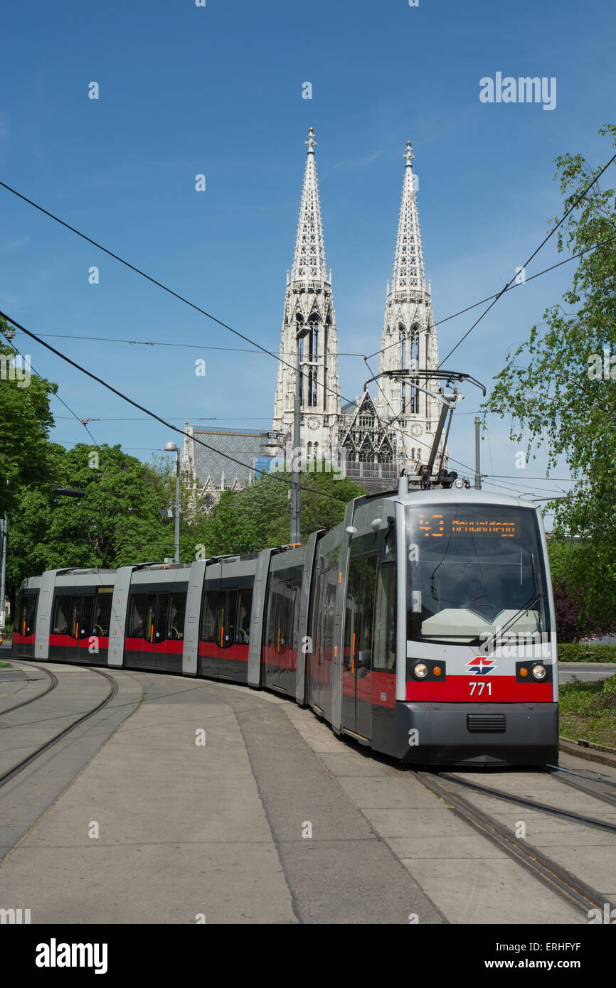 7 Parte bassa pianale tram articolato sul percorso 43 arriva a Schottentor tram ferma. Le torri della Chiesa Votiva sono dietro di essa Foto Stock