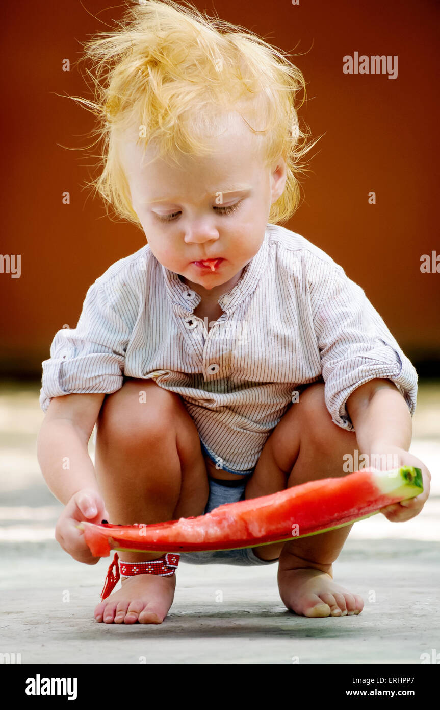 Carino neonato Bambino con una deliziosa cocomero Foto Stock