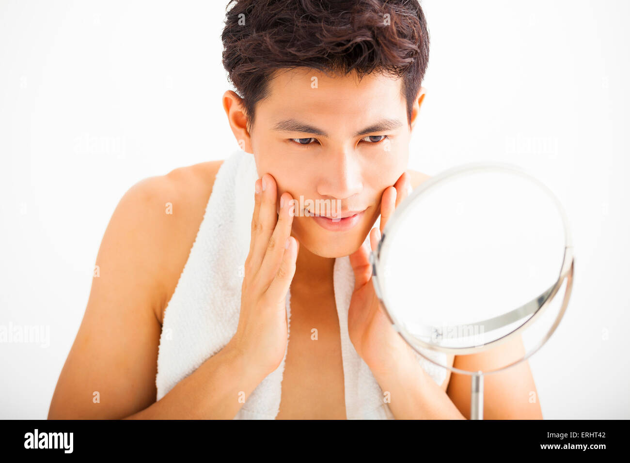 Giovane uomo di toccare la sua faccia liscia dopo la rasatura Foto Stock
