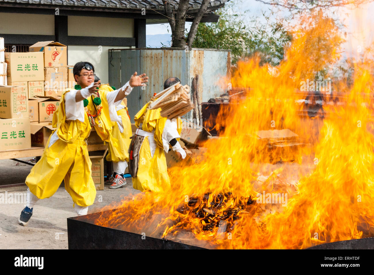 Giappone, Nishinomiya, Mondo Yakujin tempio. Masterizzazione annuale rituale, con giallo derubato yamabushi monaci, Shugendo, gettando scatole di vecchie omikuji nel fuoco. Foto Stock