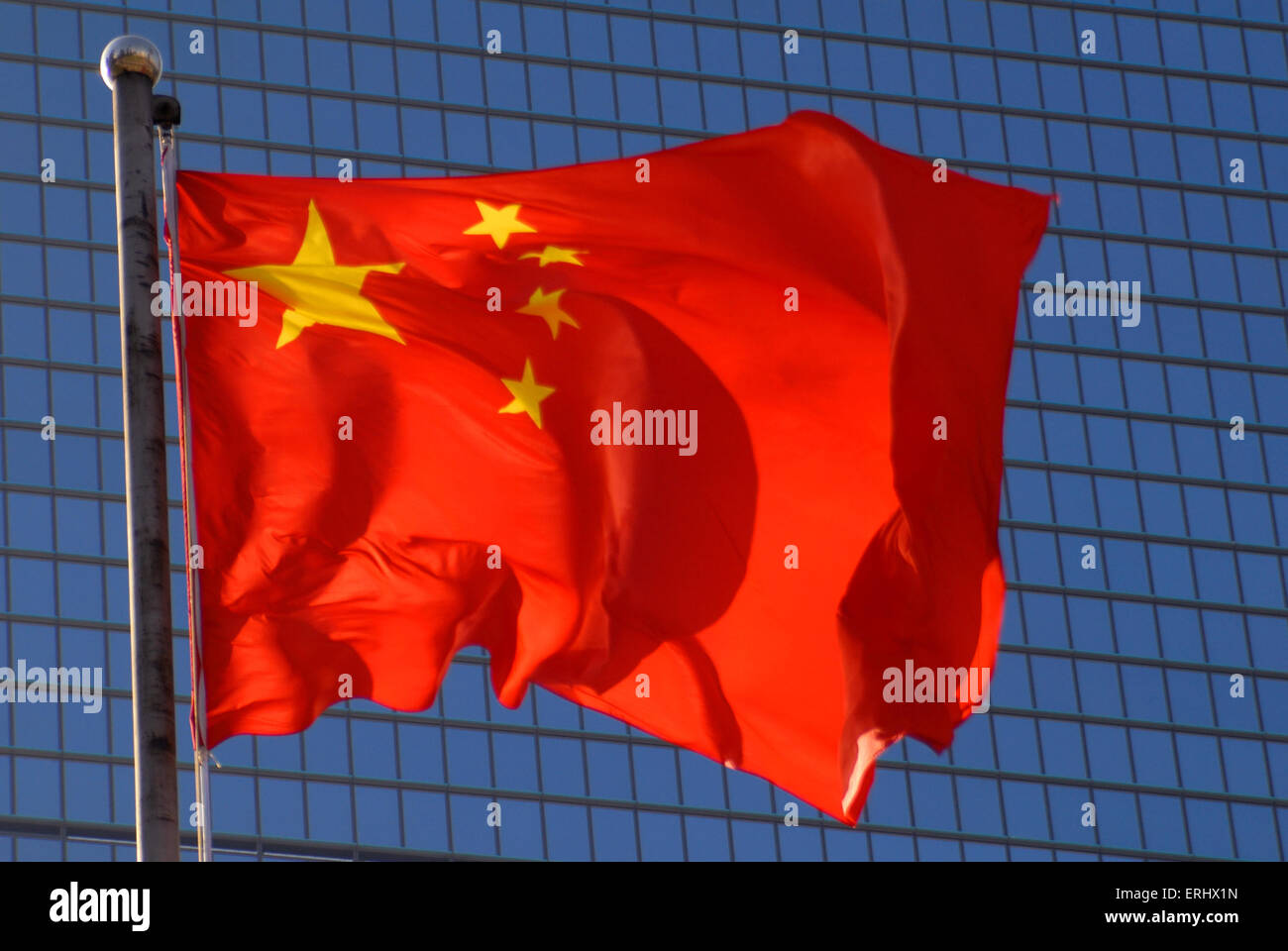 Bandiera cinese con un ufficio moderno edificio sullo sfondo. Foto Stock