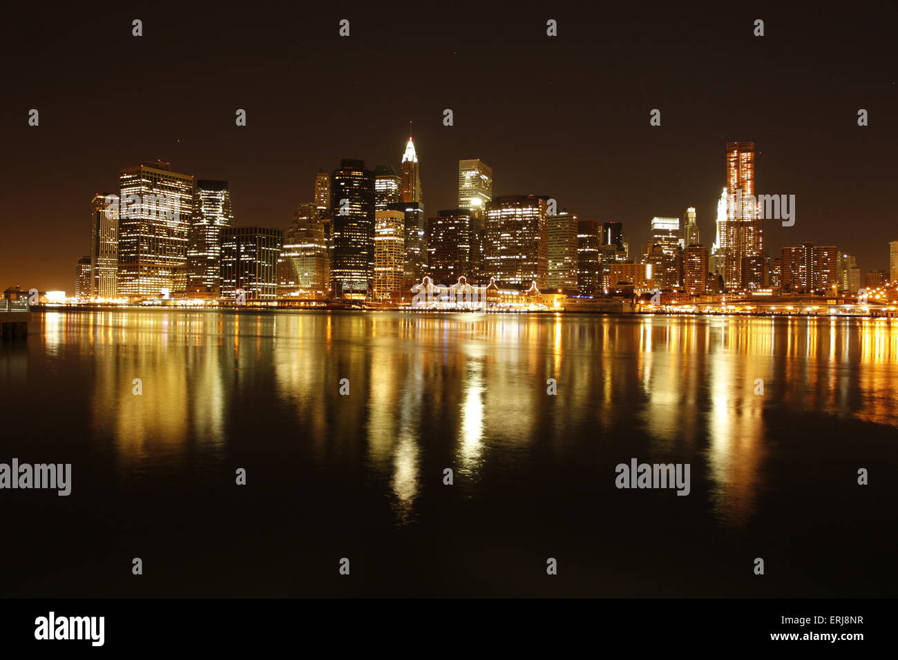 La città di New York skyline notturno attraverso il fiume Foto Stock