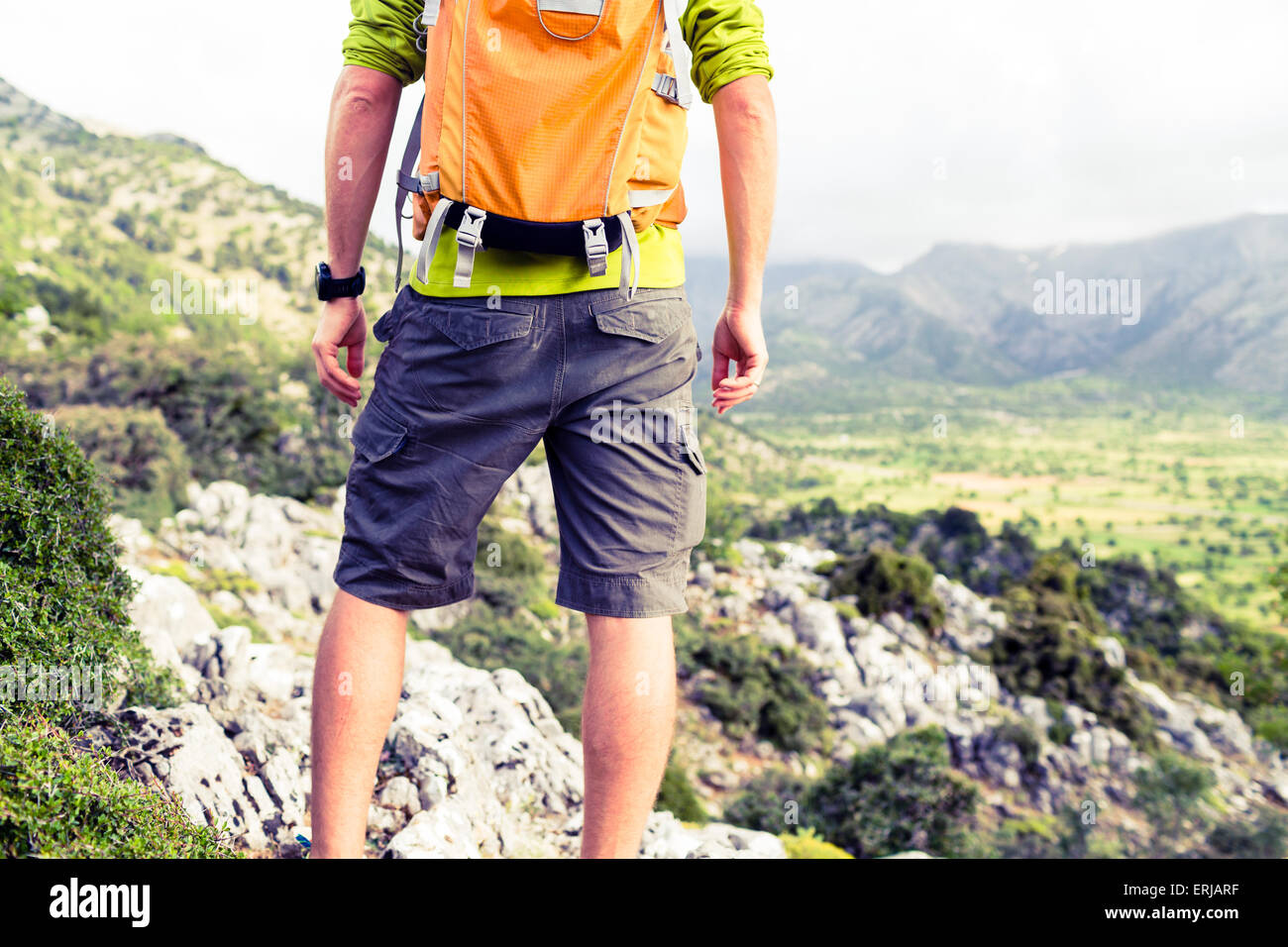 Escursionismo uomo guardando bella vista montagne paesaggio di ispirazione. Escursionista trekking con zaino sul sentiero roccioso sentiero. Egli Foto Stock