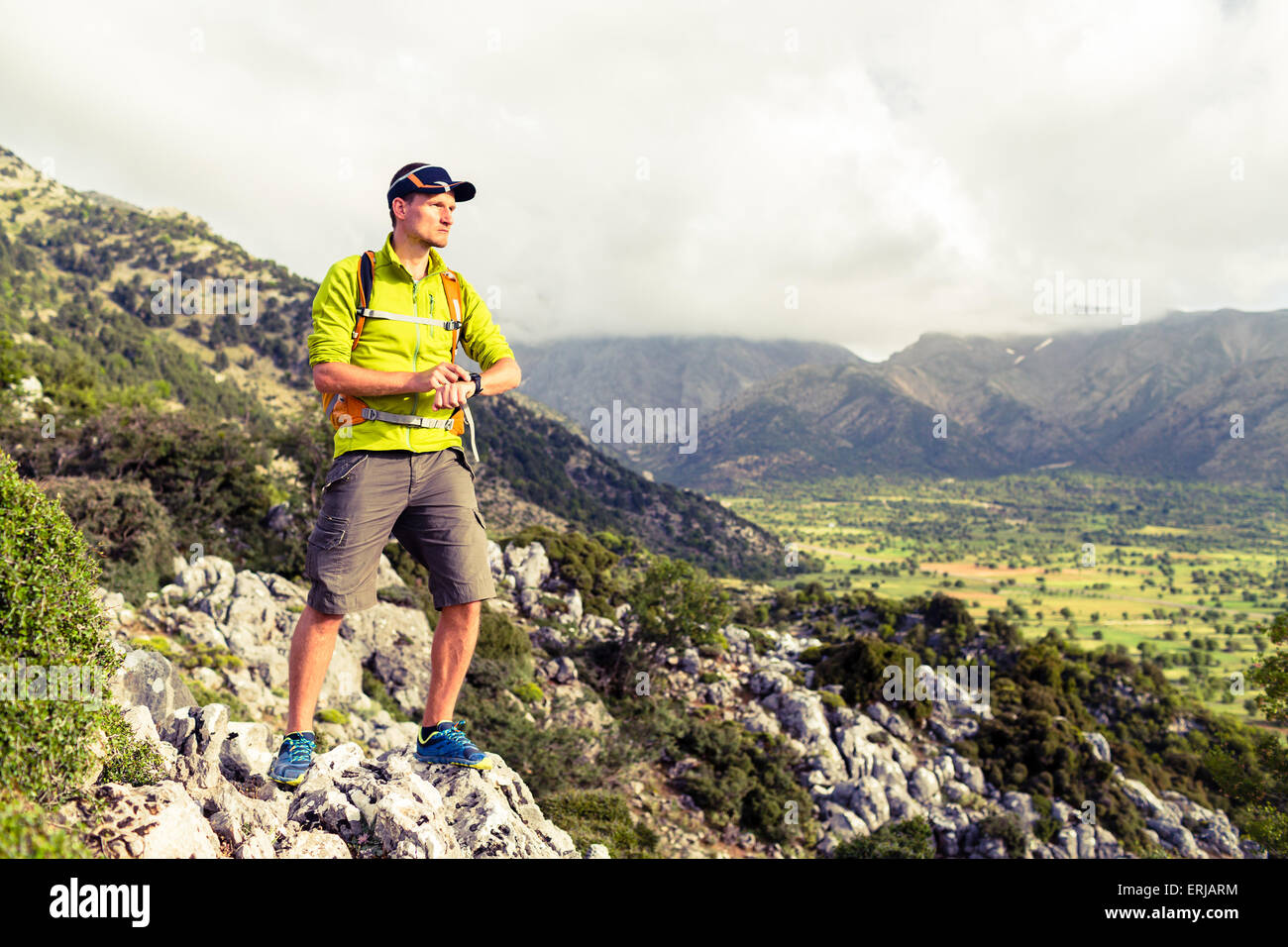 Escursionismo uomo controllo direzione in montagna. Escursionista trekking in inspirational bellissimo paesaggio guardando a vista e orologio GPS, s Foto Stock