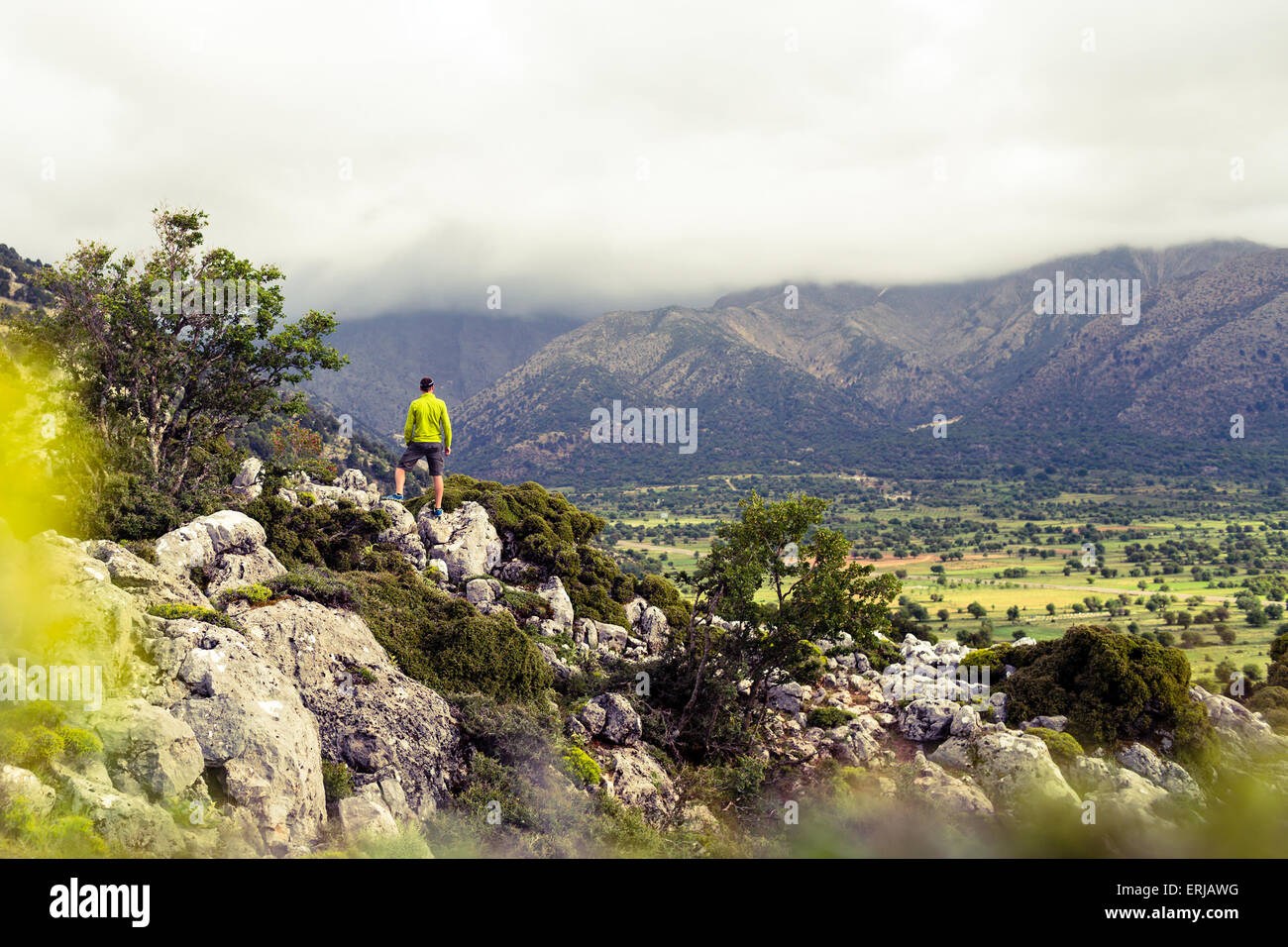 Escursionismo uomo guardando belle montagne paesaggio di ispirazione. Escursionista trekking con zaino sul sentiero roccioso sentiero. Un sano Foto Stock