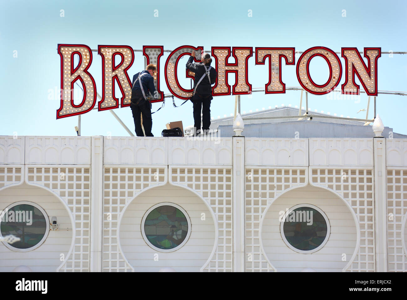 Gli uomini di manutenzione sostituire alcuni dei 62.000 lampadine si prende per illuminare il Brighton Pier. Obbligatorio byline James Boardman Foto Stock