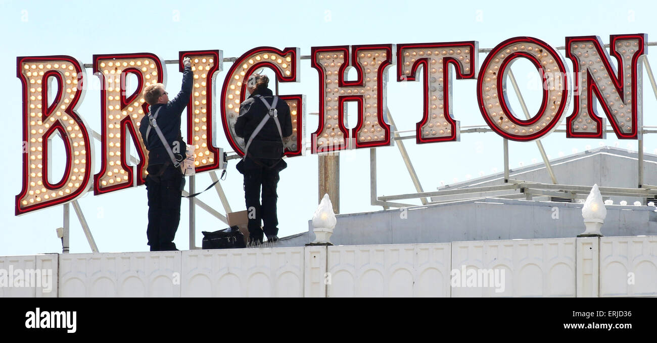 Gli uomini di manutenzione sostituire alcuni dei 62.000 lampadine si prende per illuminare il Brighton Pier. Obbligatorio byline James Boardman Foto Stock