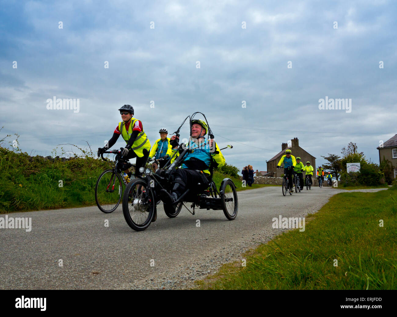 I ciclisti che partecipano in una carità sponsorizzati in bicicletta in Anglesey North Wales UK con bici da corsa e un tre ciclo di ruota Foto Stock
