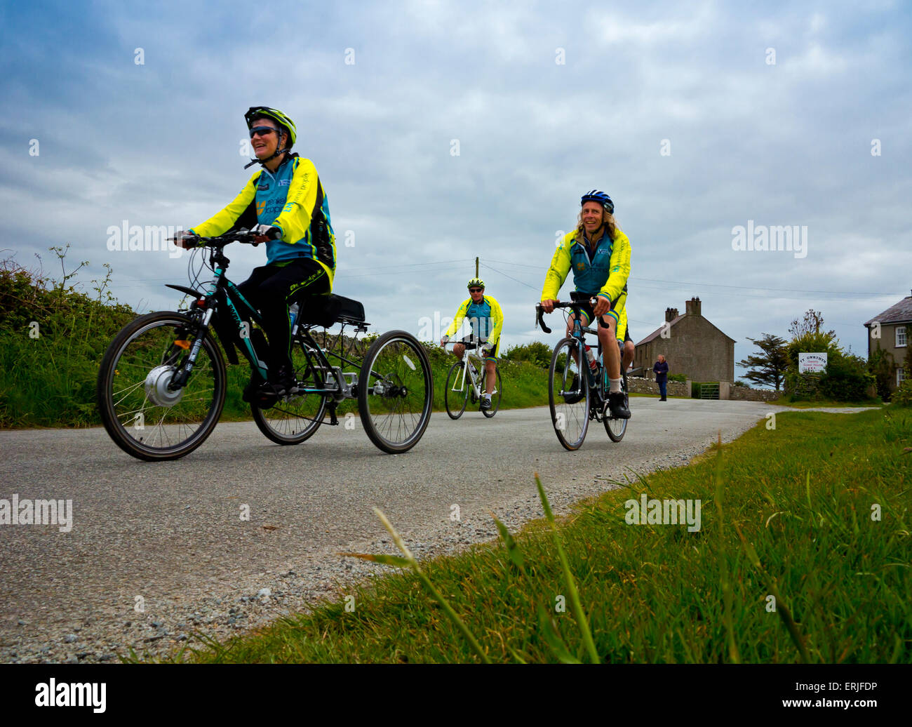 I ciclisti che partecipano in una carità sponsorizzati in bicicletta in Anglesey North Wales UK con bici da corsa e un tre ciclo di ruota Foto Stock