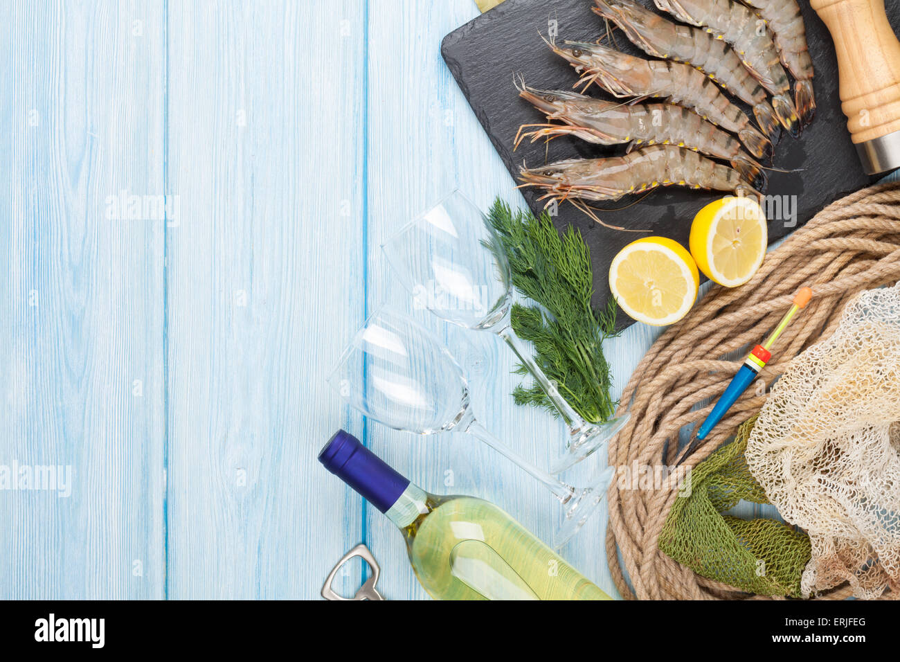 Crudo fresco gamberoni, spezie e vino bianco su tavola di legno con spazio di copia Foto Stock