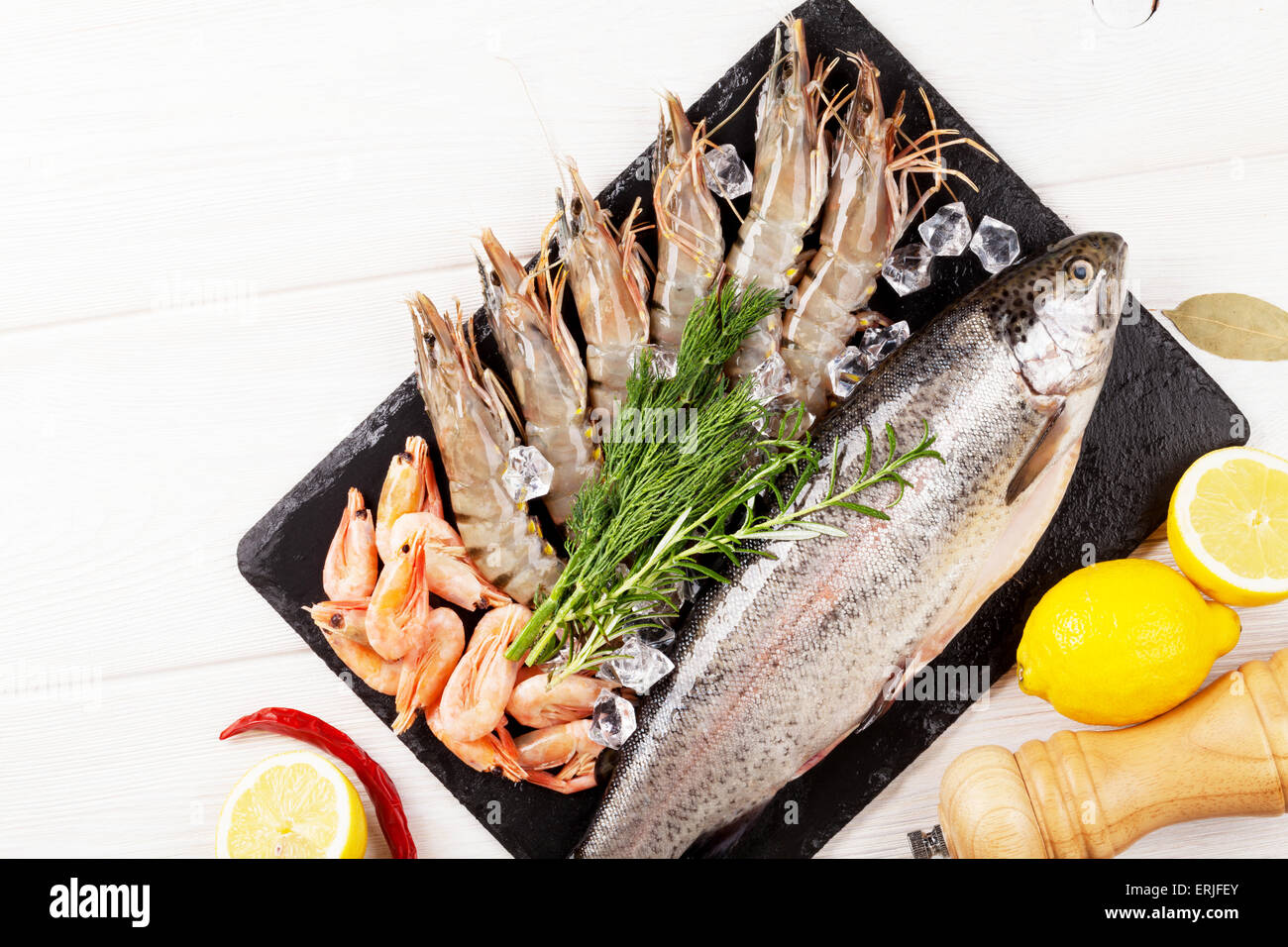 Crudo fresco il cibo del mare con spezie sulla lastra di pietra su un tavolo di legno dello sfondo. Vista da sopra con lo spazio di copia Foto Stock