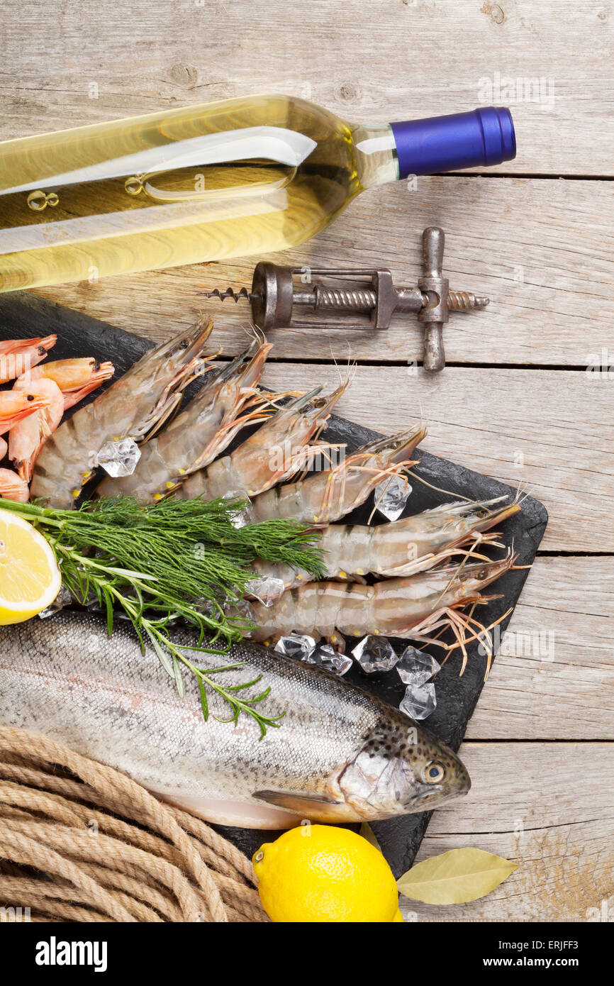 Crudo fresco il cibo del mare con spezie e vino bianco su tavola di legno dello sfondo. Vista superiore Foto Stock