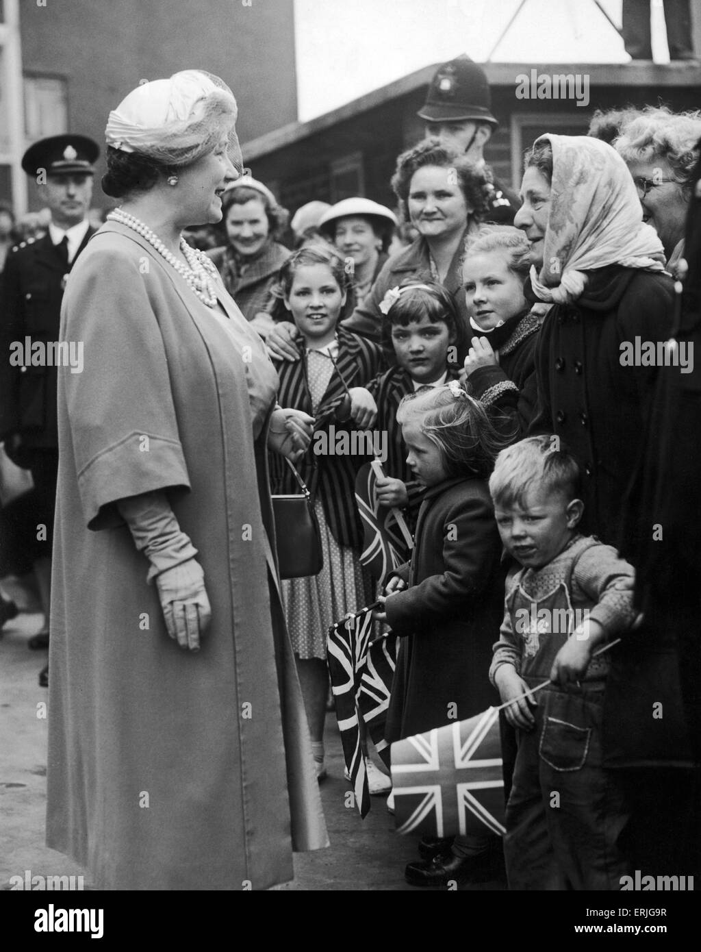 La regina Elisabetta Regina madre saluta la folla riunita al di fuori del Great Colmore Street Station Wagon appartamenti in Grant Street durante la sua visita a Birmingham. Il 2 maggio 1957. Foto Stock