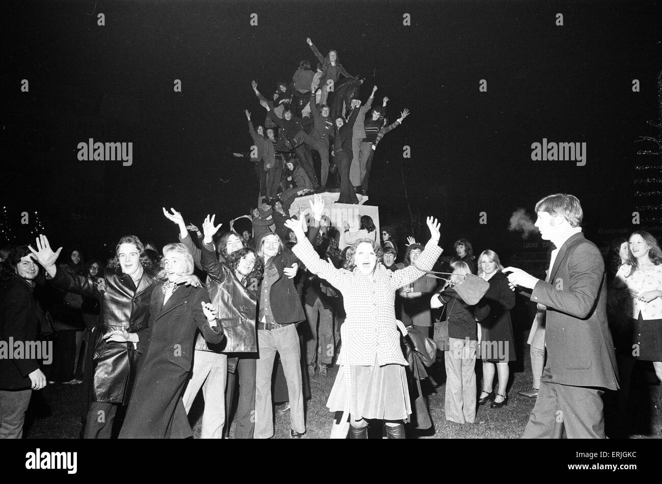 Un felice folla di giovani salutare il nuovo anno in alta spiriti in Broadgate, Coventry. Ma per un giovane è un molto più circostanza personale. Il 1 gennaio 1973. Foto Stock