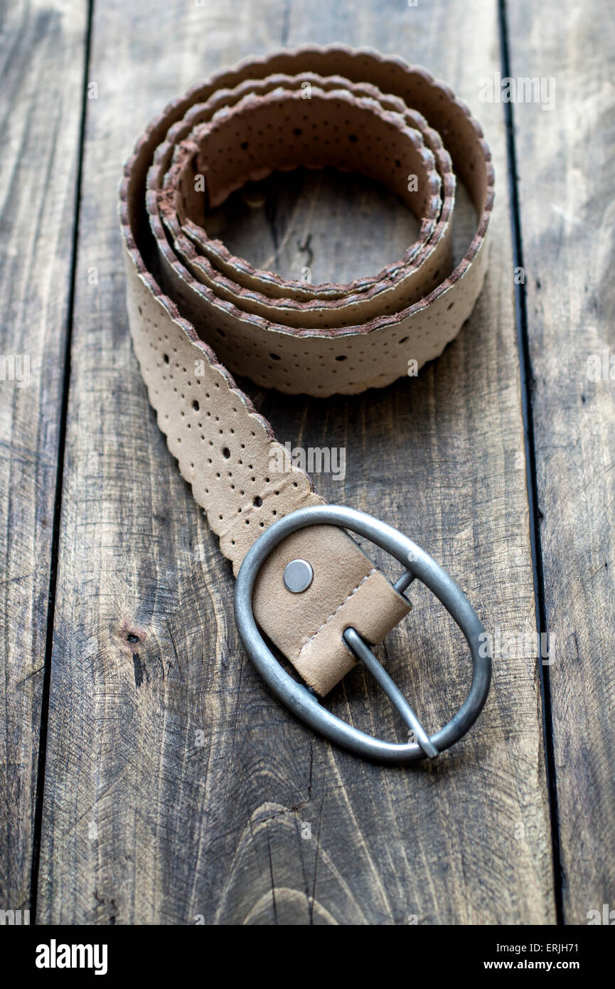 Cintura in cuoio sul tavolo di legno, close up Foto Stock
