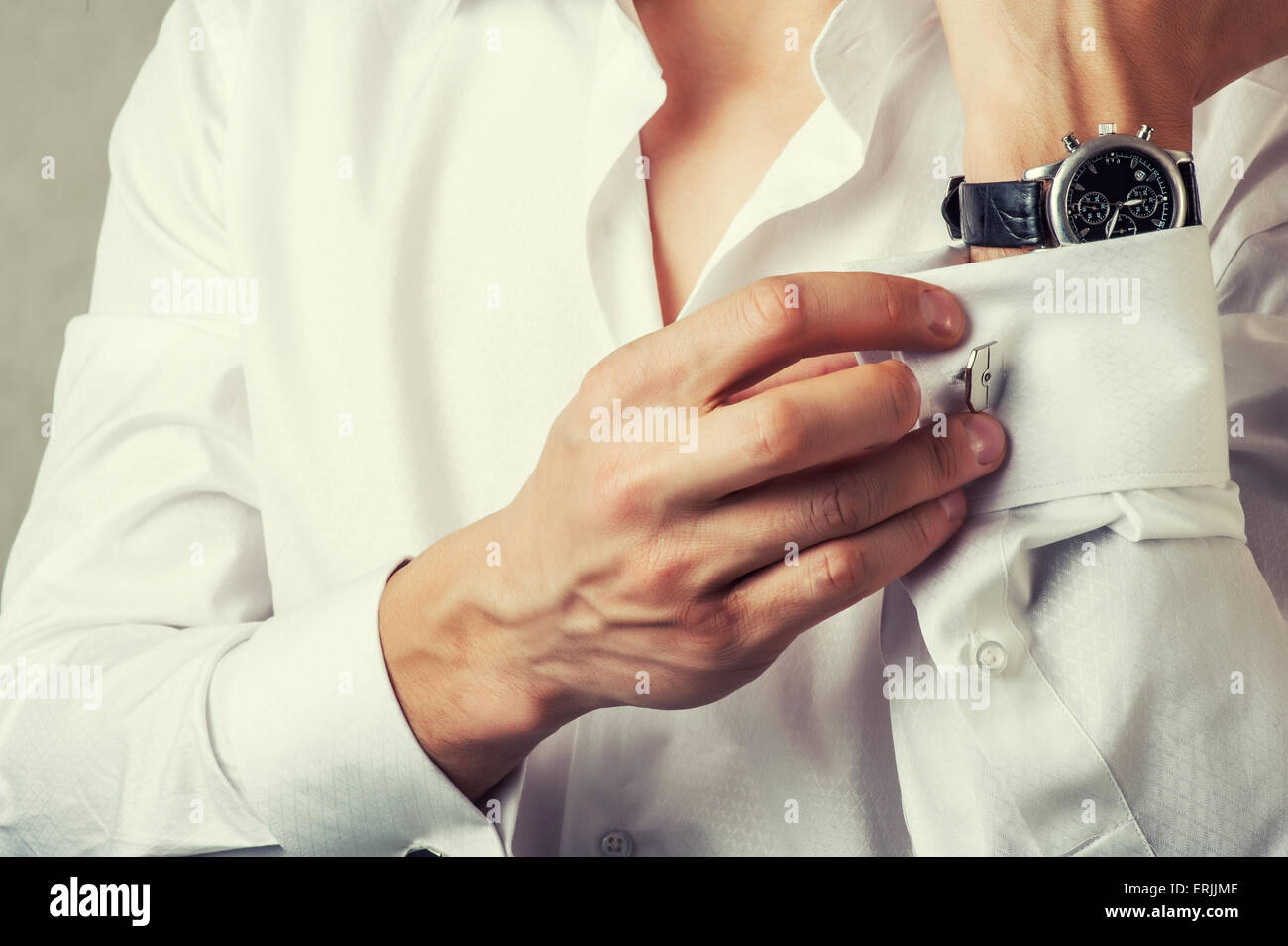 Uomo bracciale pulsanti-link sul francese polsini maniche luxury camicia bianca. La correzione delle tonalità Foto Stock