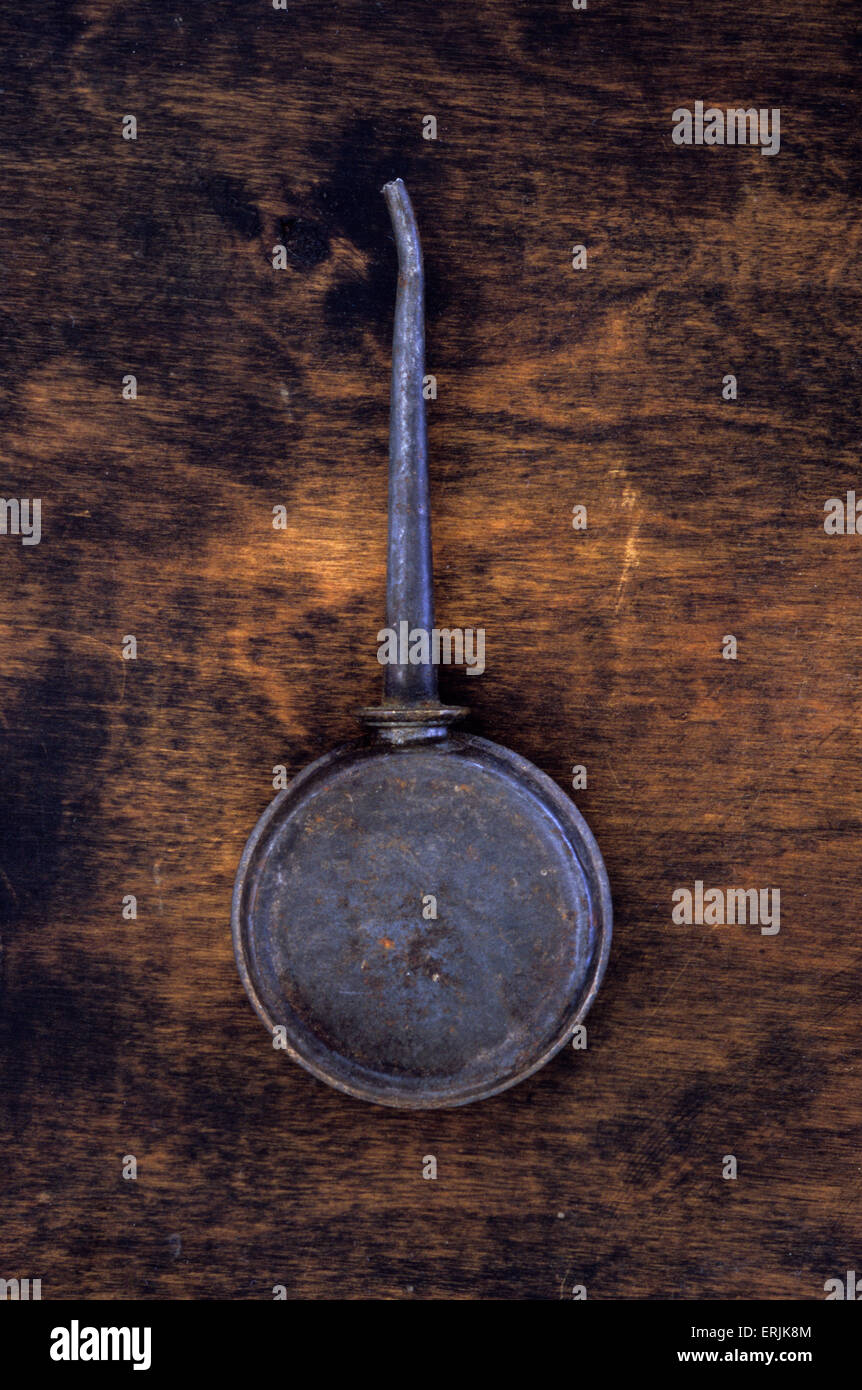 Piccola mano vintage olio può con il serbatoio di metallo e il tubo di lancio molto utilizzato e opacizzato giacente sul legno scuro Foto Stock