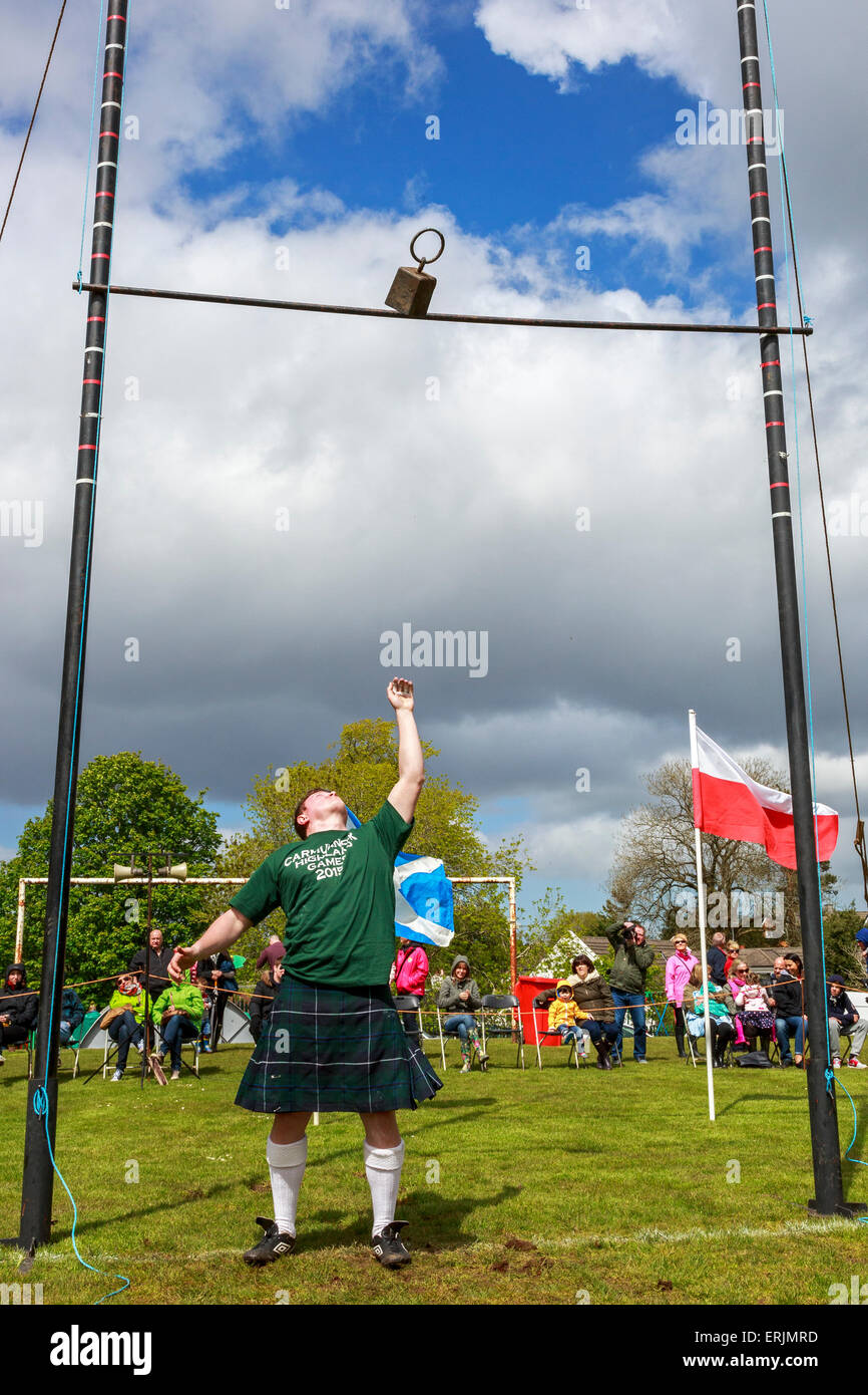 Uomo di gettare il peso al di sopra del bar, un tradizionale stile di gioco durante un Highland Games incontro, Carmunnock, Glasgow, Scozia Foto Stock