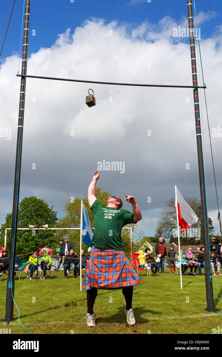 Uomo di gettare il peso al di sopra del bar, un tradizionale stile di gioco durante un Highland Games incontro, Carmunnock, Glasgow, Scozia Foto Stock