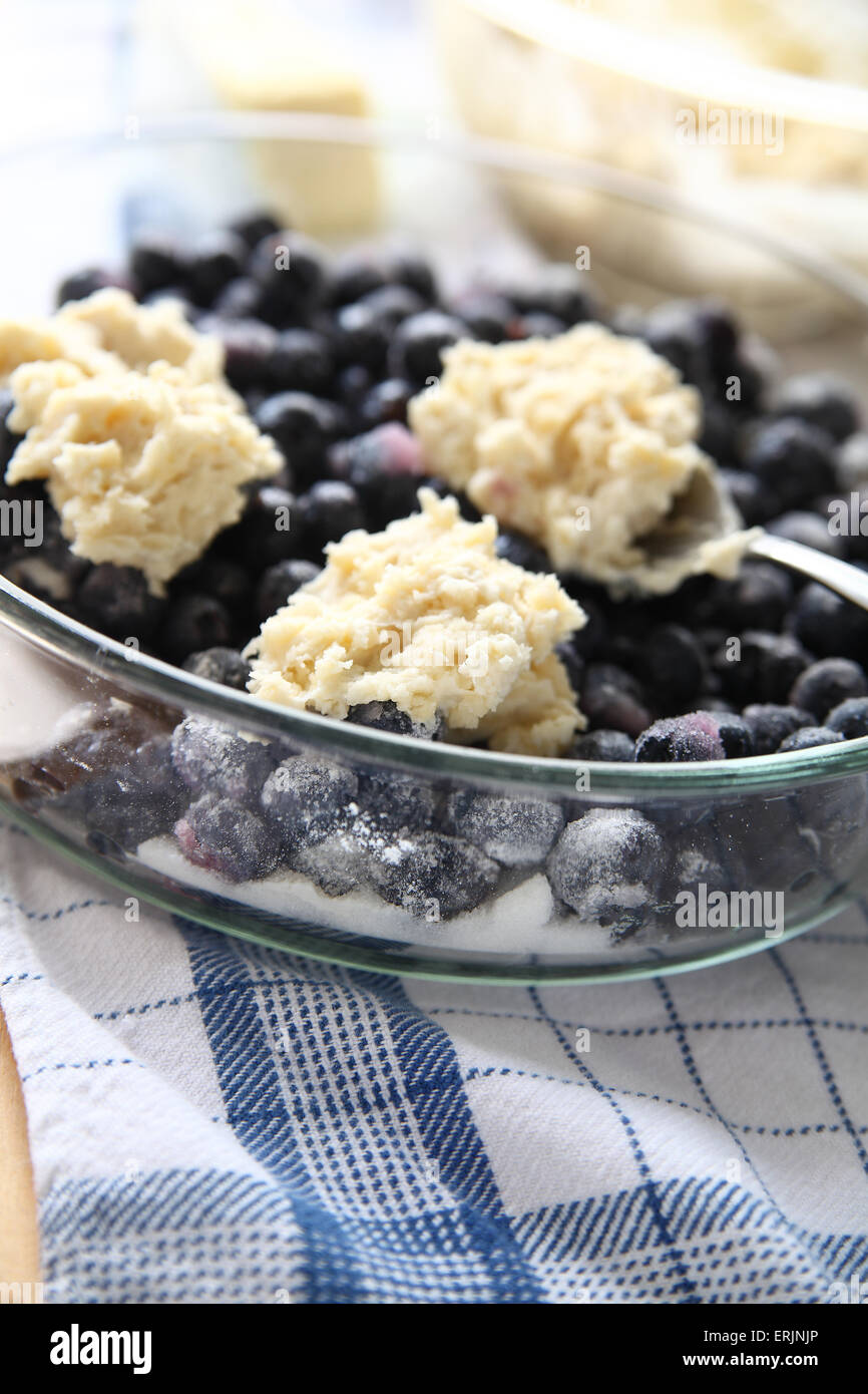Mettere il biscotto topping di freschi confetti di mirtilli Foto Stock