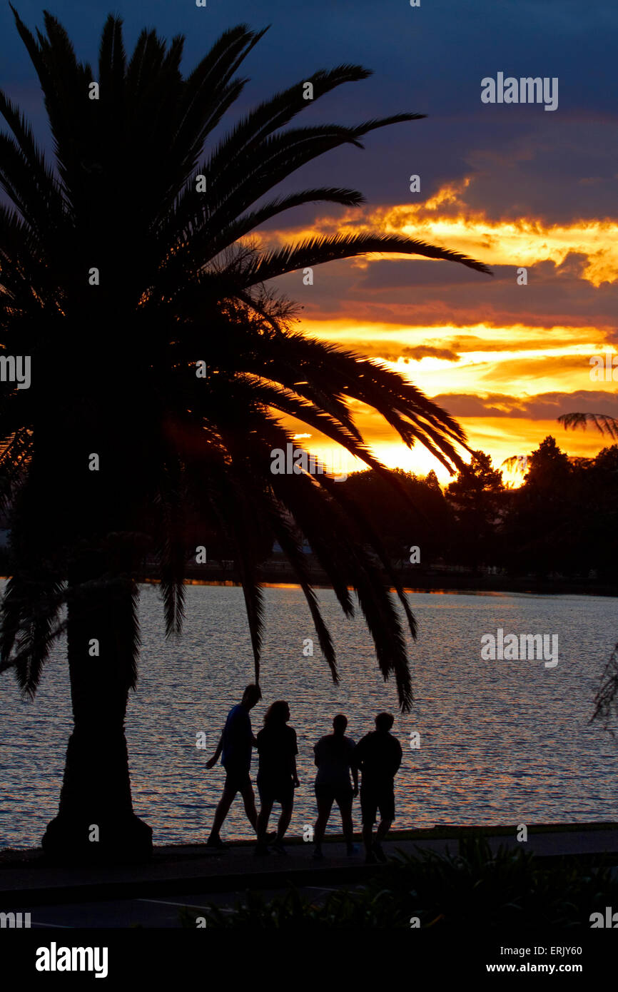 La gente a piedi dal lago Rotoroa al tramonto, Hamilton, Waikato, Isola del nord, Nuova Zelanda Foto Stock