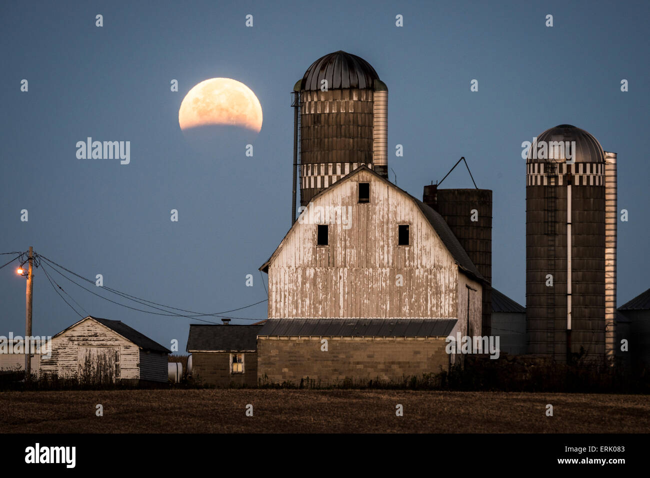 Eclissi lunare parziale su edifici agricoli vicino a Shakopee, Minnesota. Foto Stock