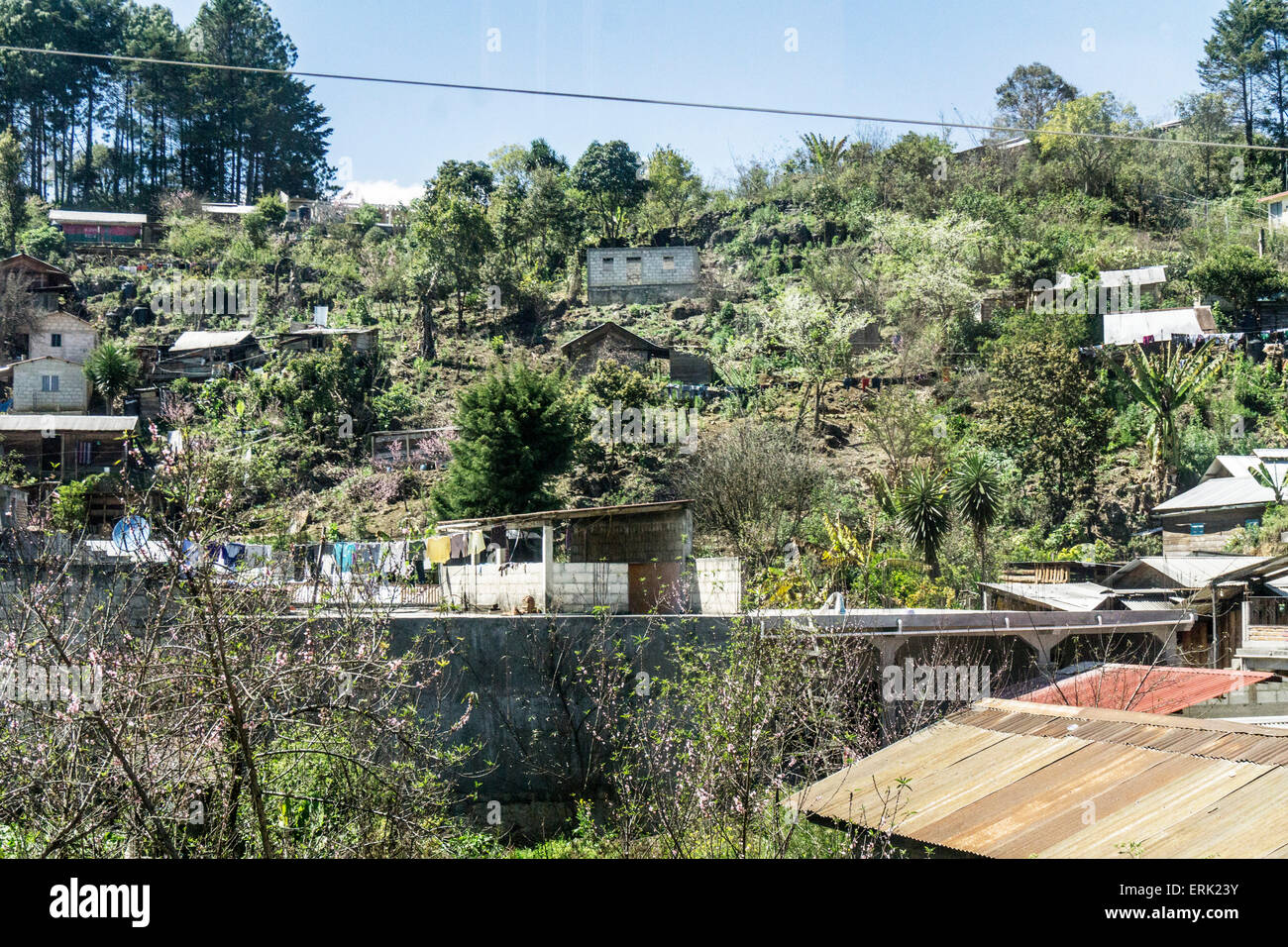 Pittoresco gruppo di blocco di scorie case con ondulato tetti di stagno sulla collina che domina la strada principale in direzione di Ocosingo Chiapas Foto Stock