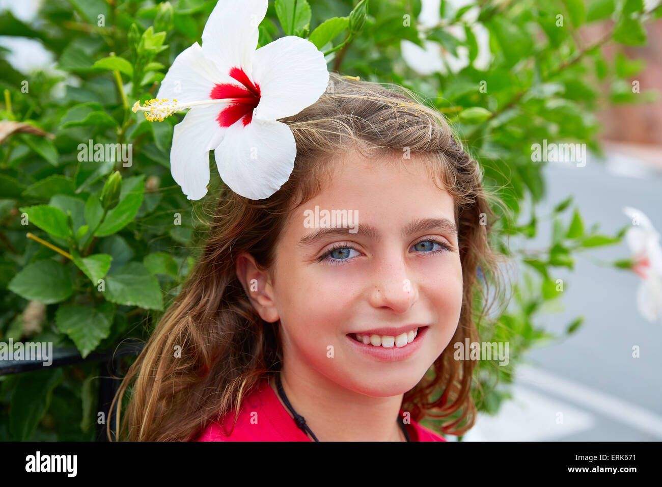 Bella ragazza di capretto con fiori di ibisco in capelli occhi blu Foto Stock