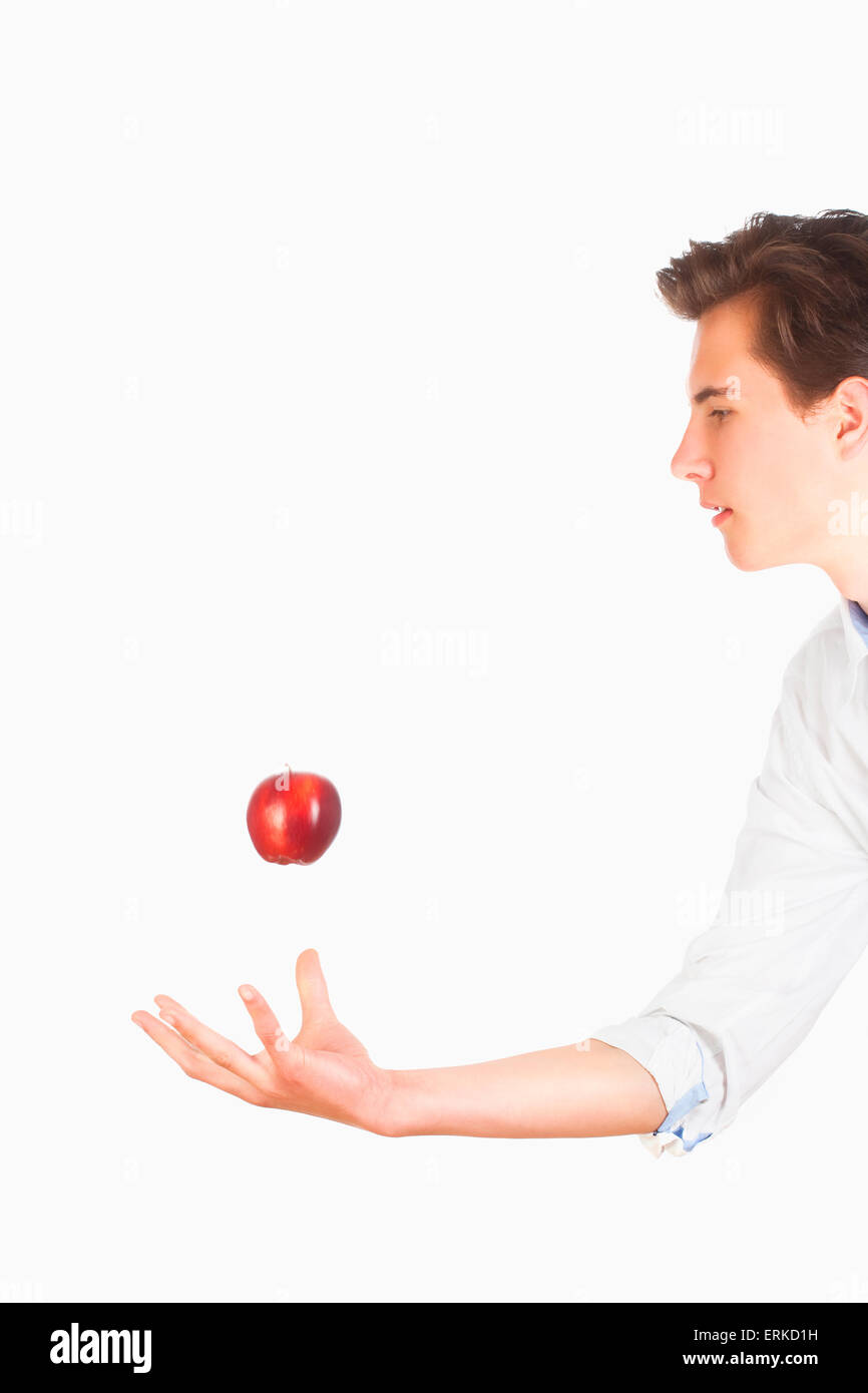 Giovane uomo nel lanciare Red Apple in aria Foto Stock Giovane uomo nel lanciare Red Apple in aria Foto Stock