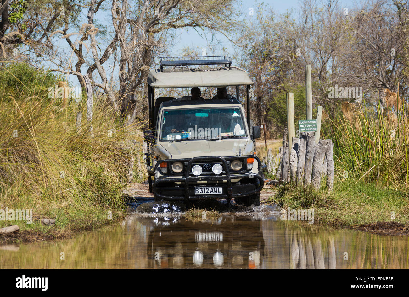 A quattro ruote vettura che attraversa un fiume, strada in Okavango Delta conduce oltre il ponte di polo il terzo ponte, Moremi Game Reserve Foto Stock