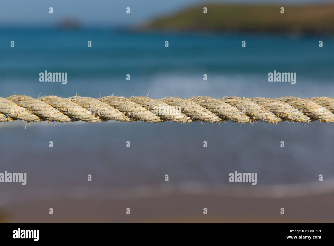 Lunghezza di corda tirato bene contro uno sfondo sfocato delle onde del mare e della costa Foto Stock