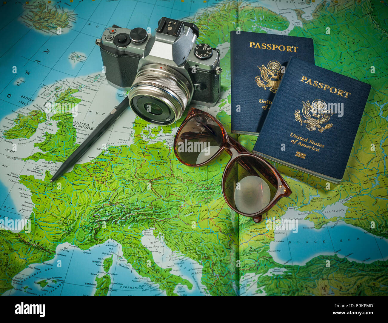 Il passaporto per viaggiare, telecamera e bicchieri su una mappa di Europa Foto Stock